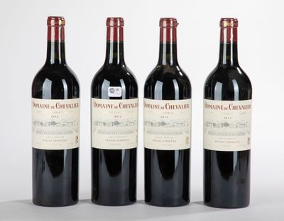 trois bouteilles de vin rouge sont alignées sur une surface blanche