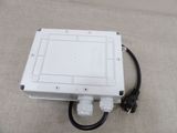 a close up of a white box on a couch with a black cord