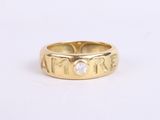 a close up of a gold ring with a diamond in the center