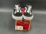 pair of black and white vans sneakers sitting on top of a box