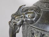 a silver vase with a dragon handle on it
