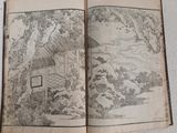 an open book with a picture of a mountain scene on it