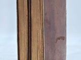 an old book that is open on a white surface