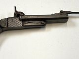 un pistolet posé sur une surface blanche