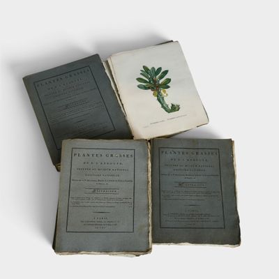 trois vieux livres empilés les uns sur les autres sur une table