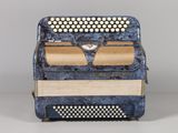 an old blue accordion sitting on top of a white table