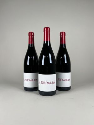 trois bouteilles de vin rouge posées sur une table