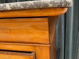 a wooden dresser with a marble top in a room