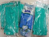 trois paires de gants verts sont emballées dans du plastique sur une surface blanche