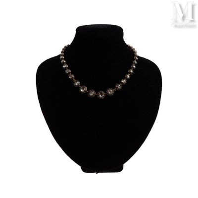 collier de perles noires présenté sur un mannequin devant un fond blanc