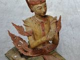 une petite statue représentant un homme assis sur un livre