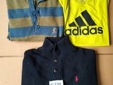 three shirts and a polo shirt are sitting on a cardboard box