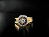 a close up of a gold ring with a black and white diamond center