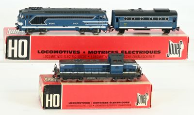 trois trains miniatures posés sur des boîtes, sur une surface blanche