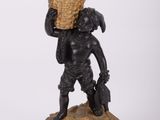 une image représentant la statue d'un garçon portant un panier sur la tête