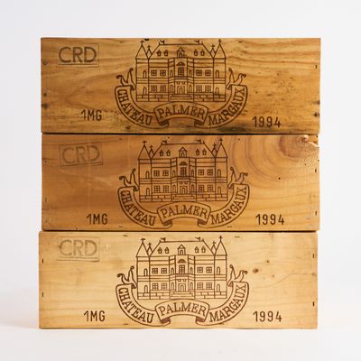 trois caisses en bois contenant différents types de vin sont empilées les unes sur les autres