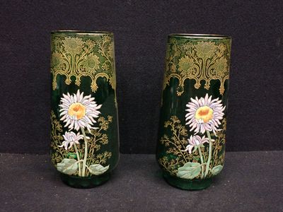 two vases with flowers painted on them sitting on a table