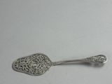 silver spoon with ornate design on it on a white surface