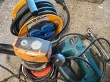 un tas d'outils électriques par terre, à côté d'une boîte