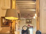 une commode sur laquelle est posée une horloge, devant un miroir