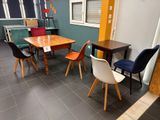 many chairs and tables in this room with a table and chairs