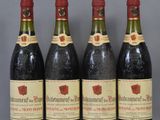 four bottles of wine are lined up on a table