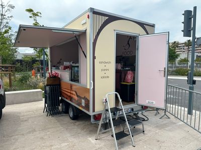un petit food truck garé au bord de la route