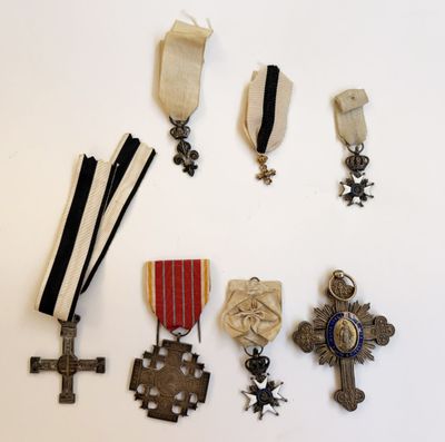 un assortiment de médailles et des médailles sont exposées sur une surface blanche
