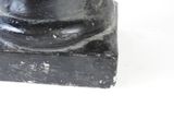 a statue of a man sitting on a black base
