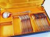 an open case with silverware in it on a table