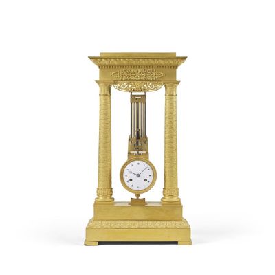 une horloge en or posée sur un socle en bois