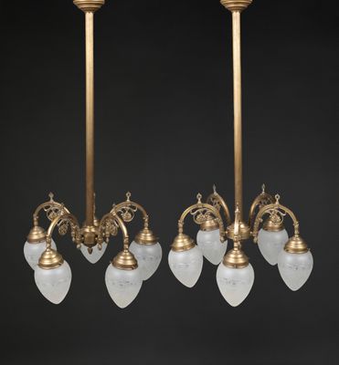 a pair of antique brass and frosted glass chandeliers