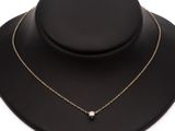 un collier en or orné d'une perle blanche sur un mannequin noir