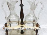 two glass pitchers and a wooden stand on a table