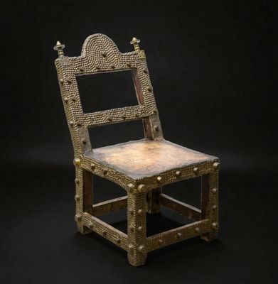 une vieille chaise en bois avec une structure métallique sur fond noir