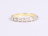 a close up of a yellow gold ring with white diamonds