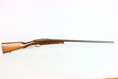 an old rifle with a wooden barrel on a white background
