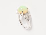an oplite and diamond ring on a white background