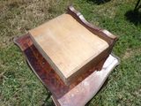 une boîte en bois posée sur une chaise dans l'herbe