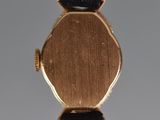 a close up of a gold watch with a black strap