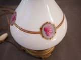 a white vase with pink flowers on it on a table