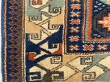 an image of a blue and red area rug with a cat on it