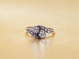 un gros plan d'une bague en diamant posée sur une surface en or