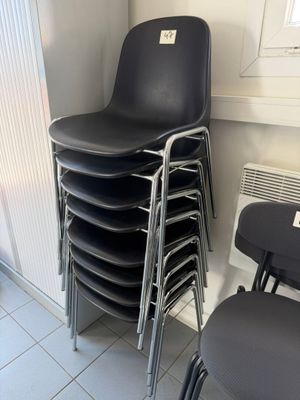 a lot of chairs that are stacked up in a room