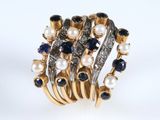 un gros plan d'une bague ornée de perles et de saphirs