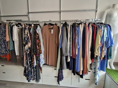 a lot of clothes hanging on a rack in a room