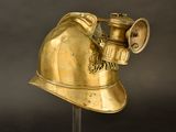 a gold fireman ' s helmet on a metal stand