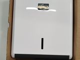 une boîte ouverte sur laquelle repose un purificateur d'air blanc, posé sur une table