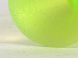a green frisbee sitting on top of a white surface