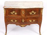 an antique chest of drawers with marble top and brass handles